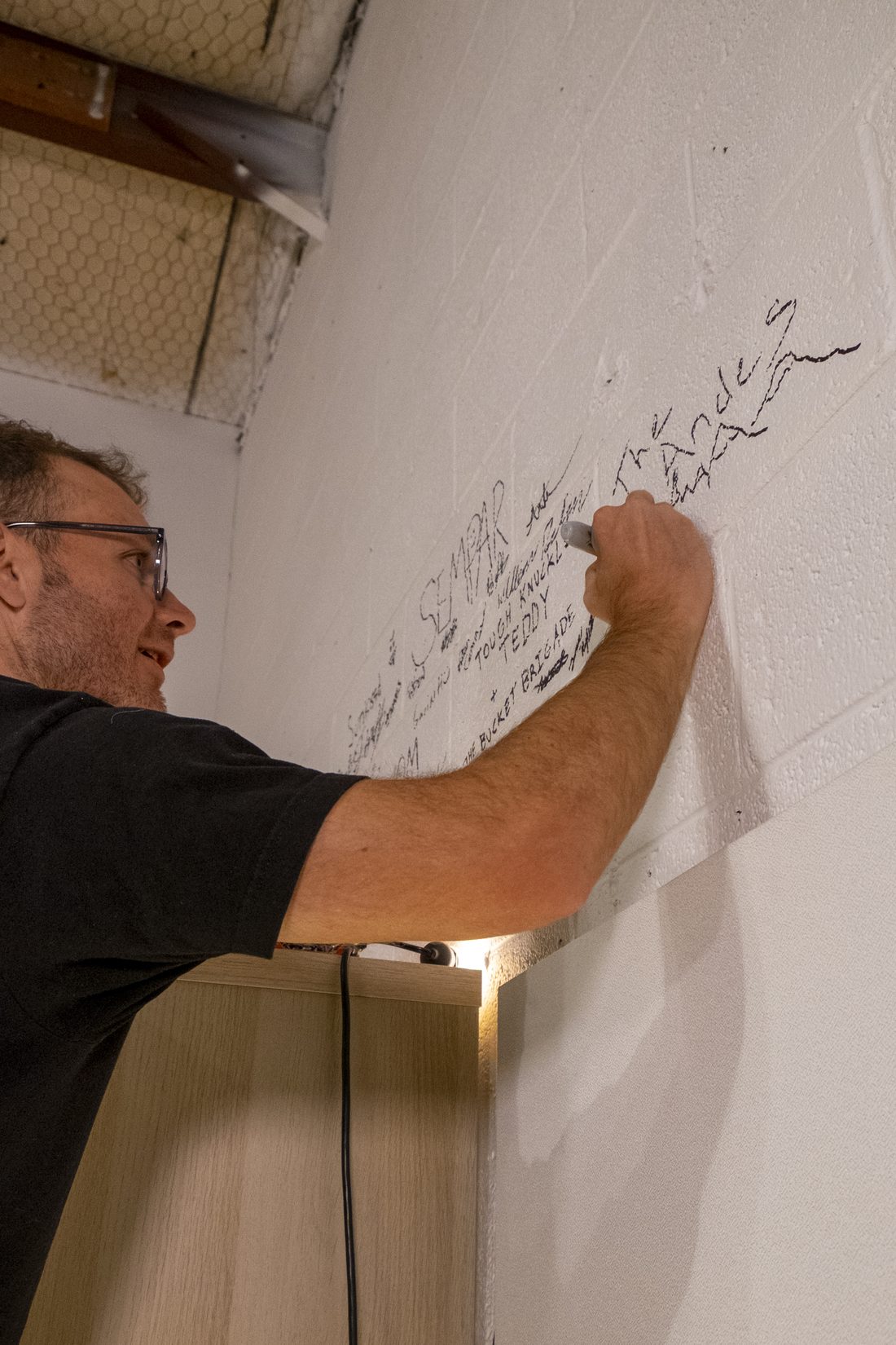 Signing The Andes onto the studio wall in marker